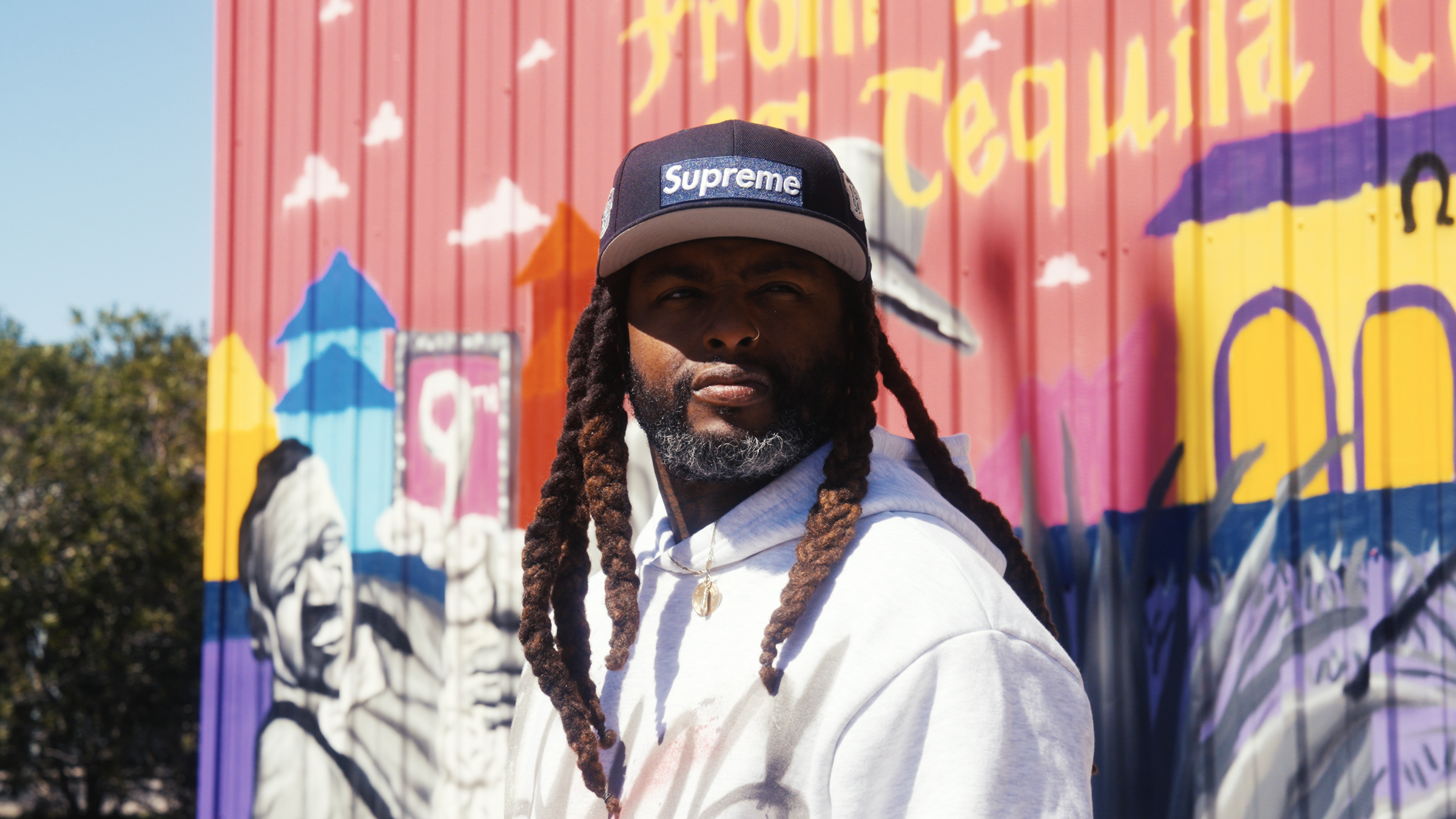 Artist Jay McKay standing in front of one of his colourful Murals in New Orleans