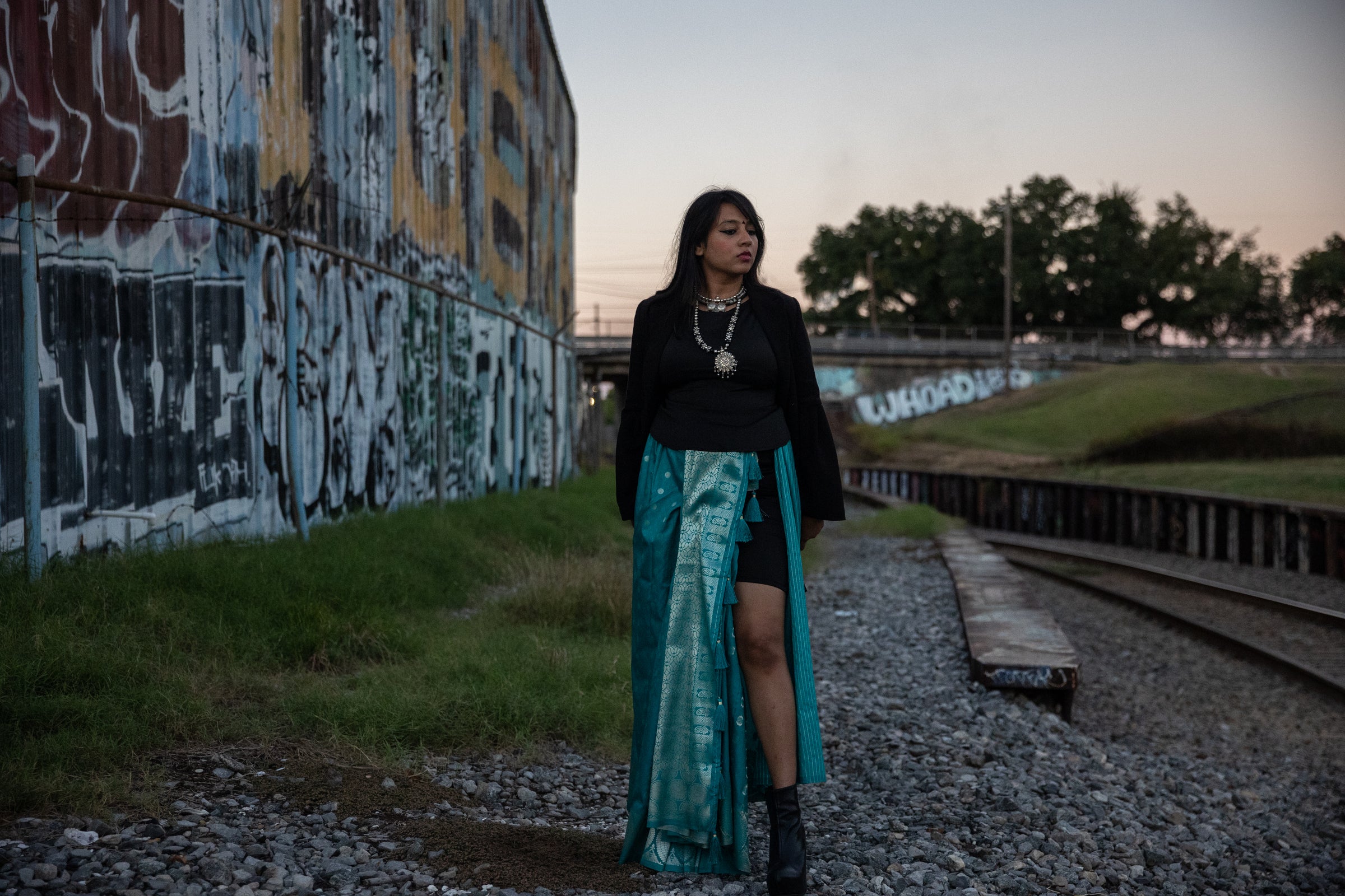 Mumbai artist Krantinaari stood aside train tracks and graffiti 