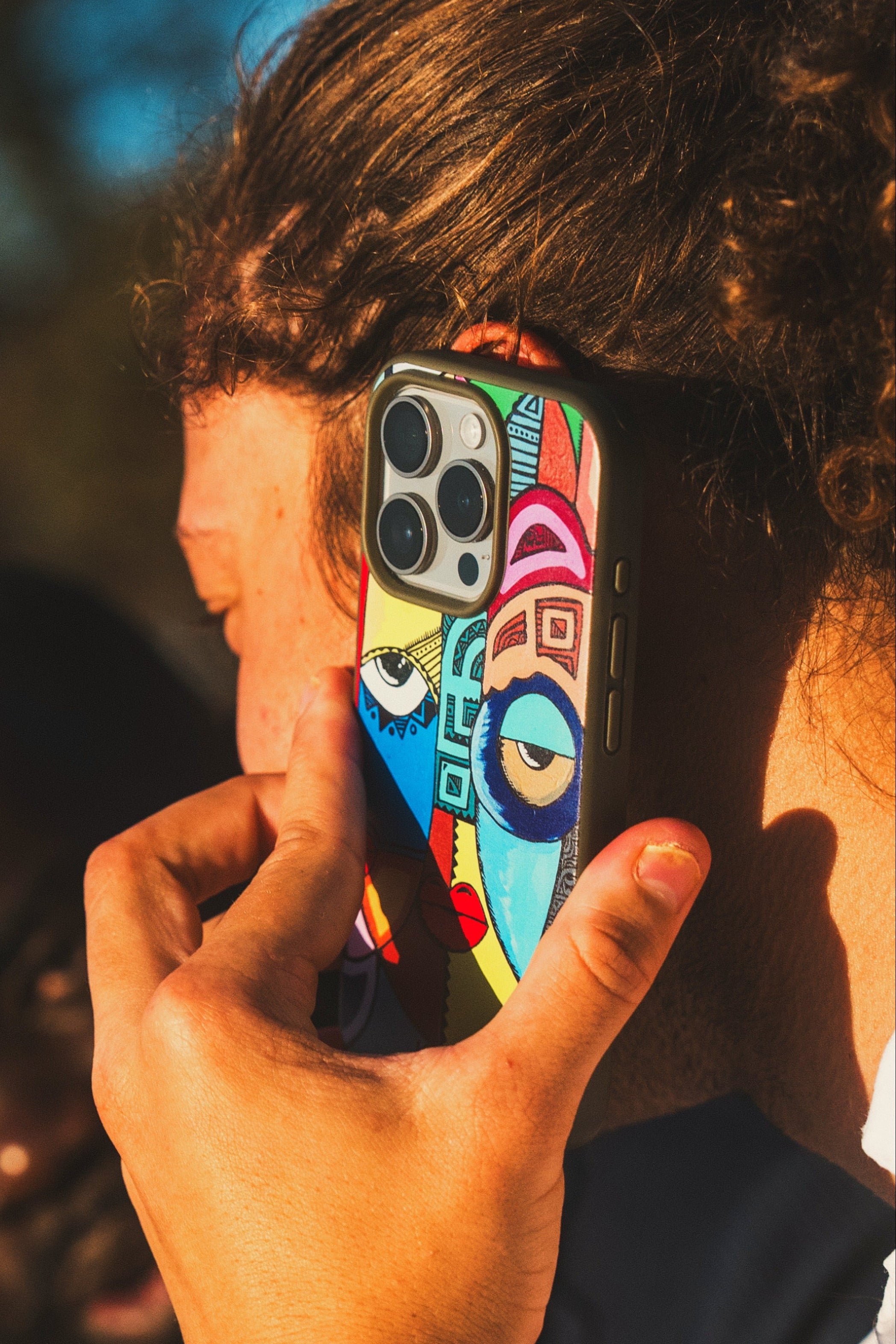 Person using a Kusudi phone case patterned with the artwork of Nairobi artist Saviour Juma 